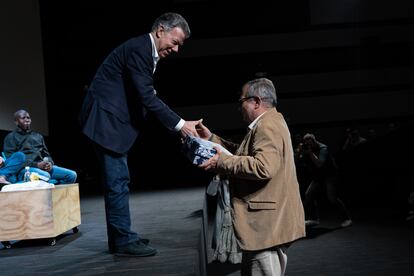 Rodrigo Londoño, ex comandante en jefe del estado mayor de las extintas FARC, recibe un regalo de Juan Manuel Santos, ex presidente de Colombia durante la tercera cumbre de la fundación Compaz, en Bogotá, el 14 de diciembre de 2022.
