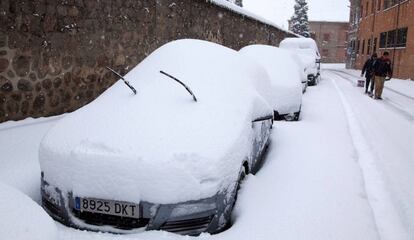 Coches cubiertos por la nieve este domingo en Ávila.