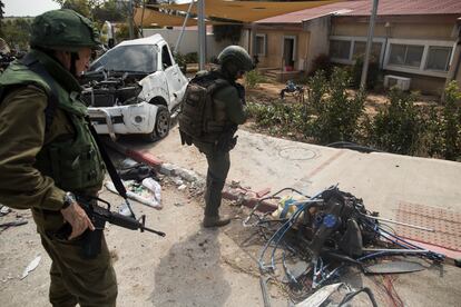 Soldados israelíes junto a un motor de un ala delta que milicianos palestinos usaron durante el ataque al kibutz Kfar Aza, cerca de la frontera con Gaza, el 10 de octubre. 