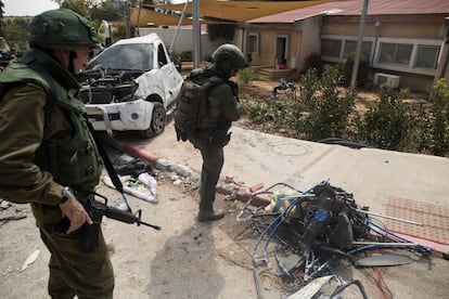 Soldados israelíes junto a un motor de un ala delta que milicianos palestinos usaron durante el ataque al kibutz Kfar Aza, cerca de la frontera con Gaza, el 10 de octubre.