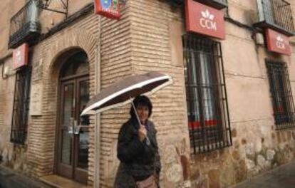 Una mujer pasa delante de la sucursal de Caja Castilla-La Mancha (CCM). EFE/Archivo