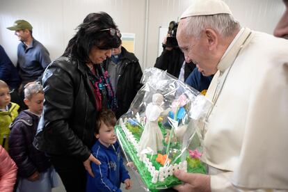 El Papa Francisco recibe un regalo durante su visita a la escuela que sufrió el terremoto de Amatrice. 