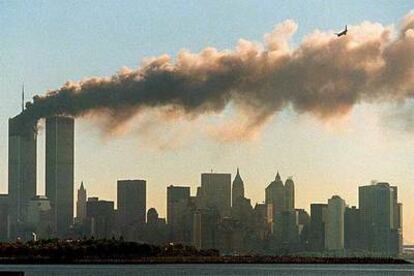 11-S de 2001: Mientras una de las Torres Gemelas arde, el segundo avión enfila su objetivo, el otro edificio.