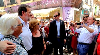 El presidente extremeño toma una foto de Rajoy junto a dos mujeres durante el paseo de ambos por Villanueva de la Serena.