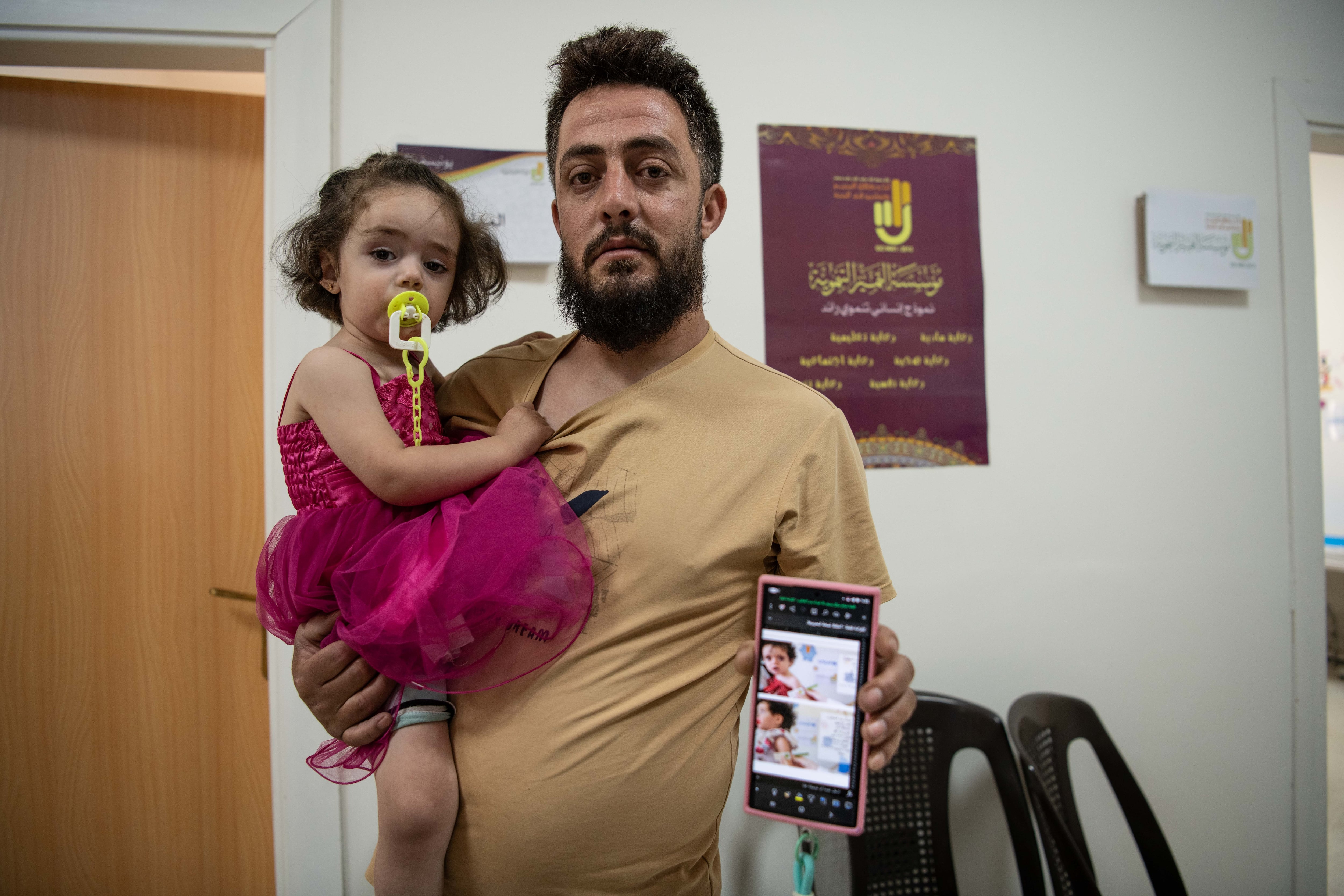 El militar Bader al Jatib (25 años) carga con su hija Ghaida que recibe tratamiento en el centro de salud Bseimeh, en la periferia de Damasco el 26 de julio.