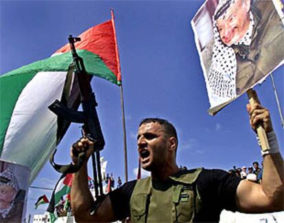 Un policía palestino sostiene un cartel con la fotografía de Yasir Arafat durante una manifestación en Gaza.