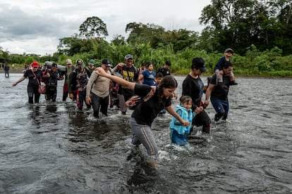 Migrantes cruzan el río Turquesa, en el tapón del Darién, la selva entre Colombia y Panamá por la que van a pie cientos de miles de personas cada año en su camino al norte, hacia Estados Unidos. Este tramo es peligroso cuando el río crece y puede arrastrar a quienes lo atraviesan.