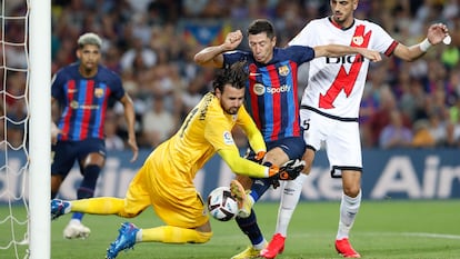 Robert Lewendowski lucha con el portero Stole Dimitrievski durante el partido entre el Barcelona y el Rayo Vallecano este sábado en el Camp Nou.