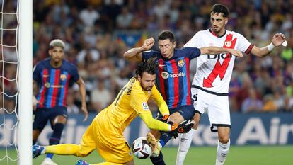 Robert Lewendowski lucha con el portero Stole Dimitrievski durante el partido entre el Barcelona y el Rayo Vallecano este sábado en el Camp Nou.