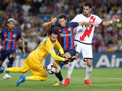 Robert Lewendowski lucha con el portero Stole Dimitrievski durante el partido entre el Barcelona y el Rayo Vallecano este sábado en el Camp Nou.