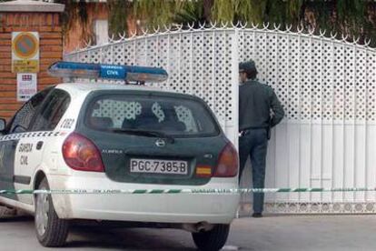 Un guardia civil en la puerta de la vivienda de la familia Ferri en Canals donde ocurrió el atraco.