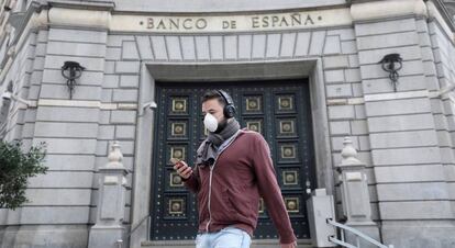 Pedestre caminha em frente ao Banco da Espanha, após o relaxamento das medidas de isolamento em Barcelona.