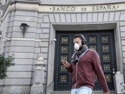 Pedestre caminha em frente ao Banco da Espanha, após o relaxamento das medidas de isolamento em Barcelona.
