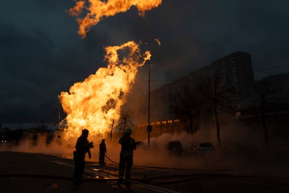 Varios bomberos intentan extinguir el incendio de una tubería de gas dañada por los ataques rusos en Kiev.