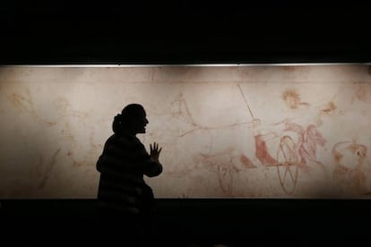 Una mujer junto a una répilica del fresco con el rapto de Perséfone en la tumba 1 de Vergina.