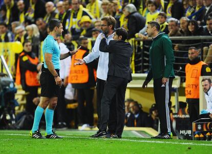 El entrenador del Villarreal, Marcelino García, tranquiliza al entrenador del Liverpool, Jürgen Klopp, mientras el árbitro Damir Skomina increpa al entrenador del Liverpool.