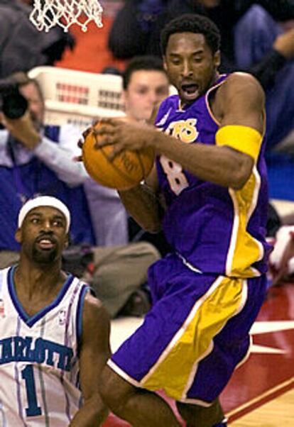 Kobe Bryant consigue un rebote ante la mirada de Baron Davis.