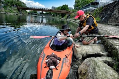 Maratoshi (80) helps Hidaka (30) into the kayak.