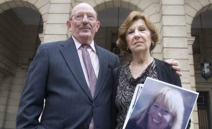 Los padres de la v&iacute;ctima, con un  retrato de ella frente a la Audiencia de Sevilla. 