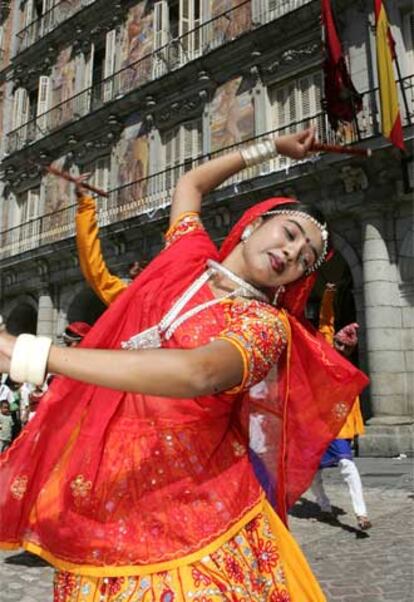 Integrantes del grupo Samanvaya (Armonía) de la provincia india de Gujarat ofrecen, ataviados con sus trajes típicos, canciones y danzas de su cultura popular a los viandantes de la Plaza Mayor de Madrid en el día de la fiesta nacional de su país.