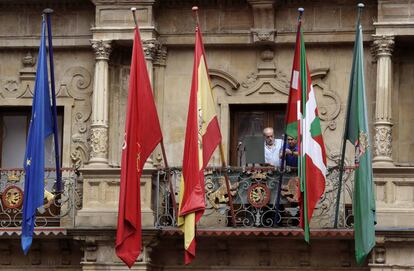Dos operarios municipales instalan este jueves la ikurriña minutos antes del chupinazo de San Fermín.