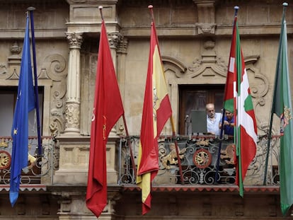 Dos operarios municipales instalan este jueves la ikurri&ntilde;a minutos antes del chupinazo de San Ferm&iacute;n. 