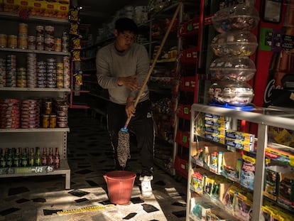 Un joven hace el aseo en una tienda en Soacha (Colombia), en mayo de 2023.