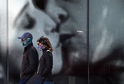 Una pareja protegida con mascarillas decoradas pasea por una calle de Washington, el pasado 22 de abril.