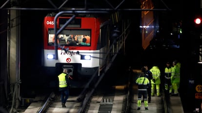 Varios operarios junto al tren de Cercanías que ha descarrilado este martes en la estación de Atocha de Madrid.