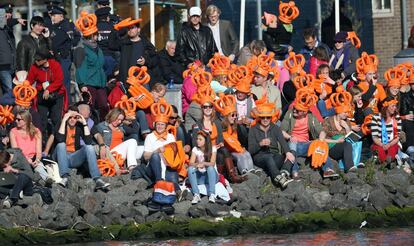 Los holandeses sentados a la orilla de uno de los canales de Ámsterdam, celebran la coronación del rey Guillermo de Holanda.