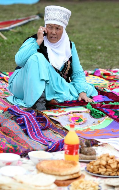 Mujer kirguiso con traje tradicional habla por teléfono móvil durante los 'World Nomad Games', en Cholpon-Ata (Kirguistán).