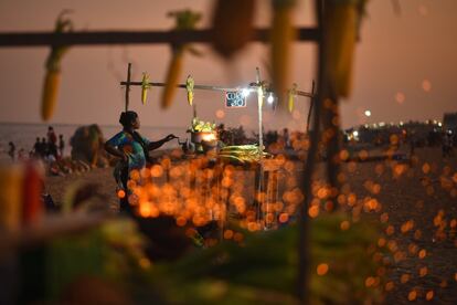 Una vendedora cocina maíz en una olla de carbón mientras espera a los clientes en Marina Beach tras la reapertura de las playas, en Chennai, India. El Gobierno del estado de Tamil Nadu ha retirado los cierres de fin de semana, los toques de queda nocturnos y reabrió las playas como parte de la relajación de las medidas sanitarias contra la covid.