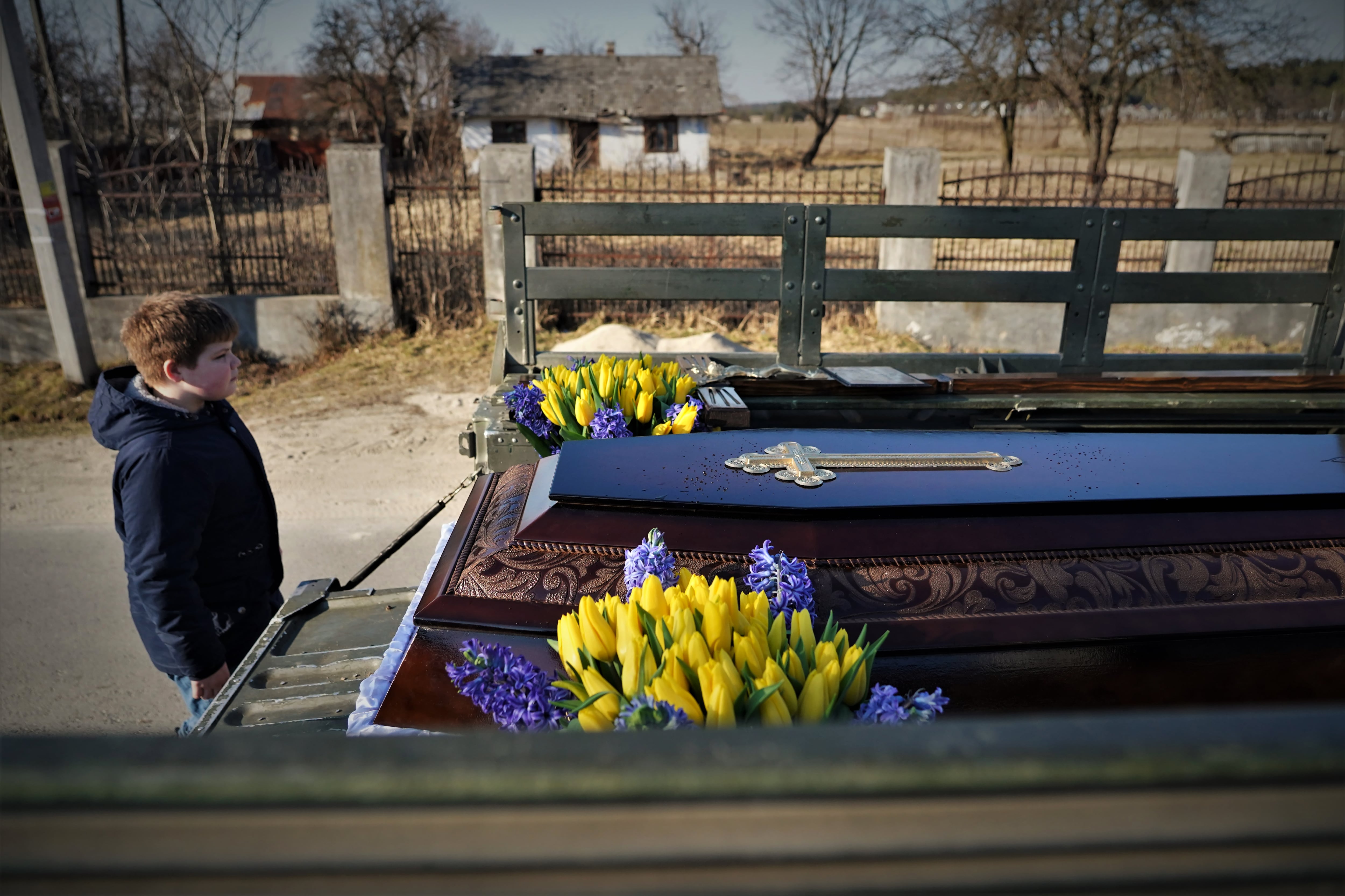 Un niño en la región de Lviv durante el entierro de su abuelo, muerto en la localidad ucrania de Bucha en 2022.