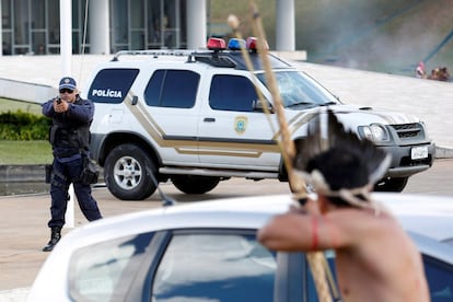 Un indígena apunta su flecha a la policía fuera del Congreso Nacional durante una protesta por la demarcación de tierras indígenas.