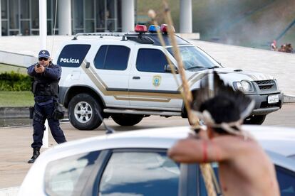 Un indígena apunta su flecha a la policía fuera del Congreso Nacional durante una protesta por la demarcación de tierras indígenas.