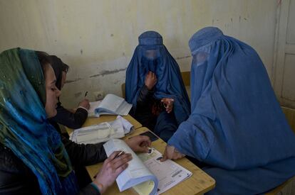 Dos mujeres se registran para votar en las elecciones presidenciales en un centro dirigido por la Comisión Electoral Independiente de Afganistán en Shah Shaheed, Kabul, el 25 de marzo de 2014.