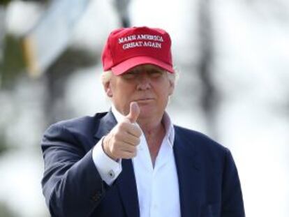 Republican presidential contender Donald Trump gestures to reporters during a golf tournament.