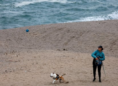 Una mujer juega con su perro en la playa de Riazor de A Coruña, el 19 de abril.