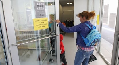 Un niño entrando en una guardería municipal acompañado de un adulto.