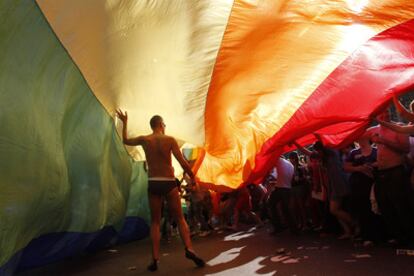 Decenas de banderas multicolor salpican el desfile. Entre ellas, alguna gigante.