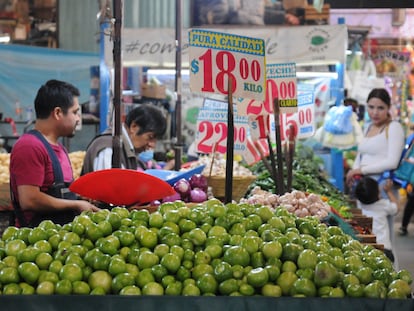 Un vendedor de frutas y verduras atiende en su puesto en un mercado en Ciudad de México.