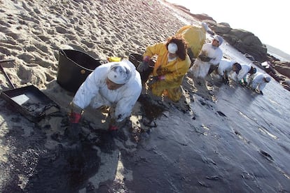 Voluntarios recogiendo chapapote en las playas de la isla de Bionta (Galicia), tras el vertido de fuel del petrolero Prestige, el 5 de diciembre de 2002.