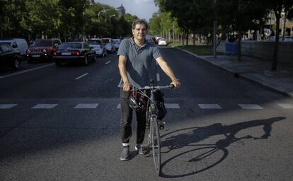 José Rossi, miembro de la Plataforma Carril Bici Castellana posa con su bici en el centro de la Castellana en Colón, Madrid.