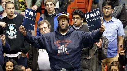 Un manifestante rompe un cartel de publicidad de Trump durante un mitin de este en Chicago en marzo de 2016.