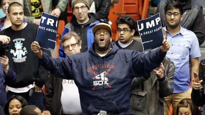 Un manifestante rompe un cartel de publicidad de Trump durante un mitin de este en Chicago en marzo de 2016.