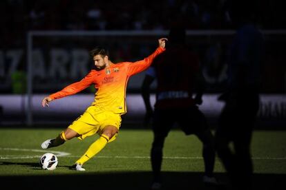 Piqu&eacute; golpea en largo durante el partido contra Osasuna.