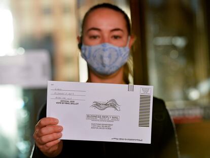 Mulher mostra uma cédula de votação pelo correio nas eleições primárias de Massachusetts, em 1º de setembro de 2020.
