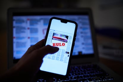 Una persona lee en su móvil una noticia falsa.