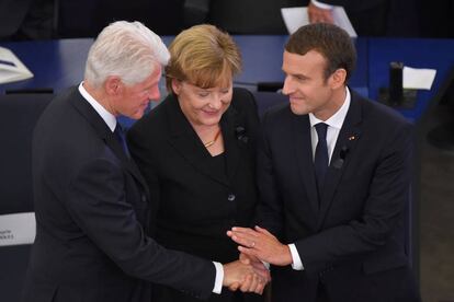 El ex presidente Clinton con Merkel y Macron en Estrasburgo.