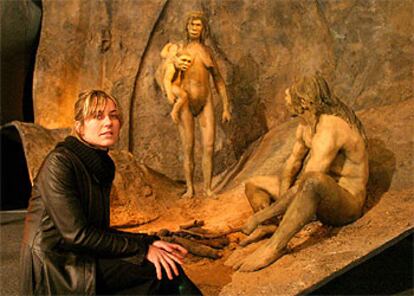 Mar Vilajosana, una de las creadoras de las figuras de la exposición <i>Del mono al hombre</i>, ante una escena que recrea la evolución humana.